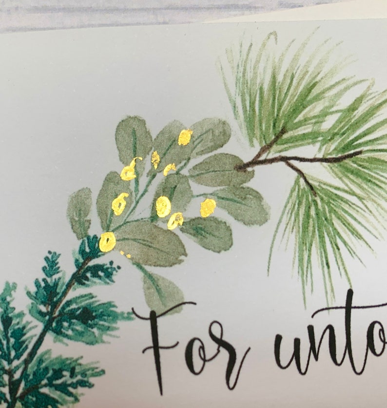 May include: A watercolor painting of a green pine branch with gold accents. The text "For unto" is written in black ink below the branch.