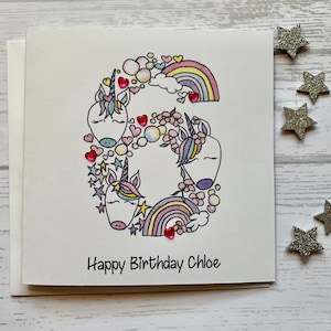 Carte personnalisée de 6e anniversaire Licorne. Illustration aquarelle de style dessin animé/griffonnage du chiffre 6 agrémentée de pierres précieuses en forme de coeur.