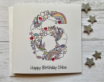 Unicorn personalised 6th  birthday card . Cartoon/doodle  style watercolour illustration of the number 6 embellished with heart gems..