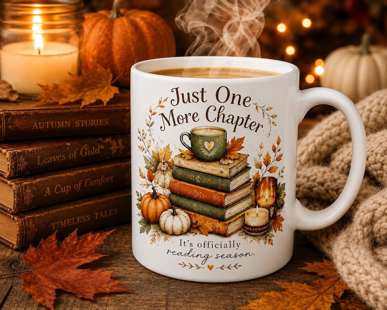 May include: A white ceramic mug featuring a graphic of a stack of books, pumpkins, and a small green cup. The text reads Just One More Chapter and It's officially reading season. The design includes autumn leaves and candles in warm colors.