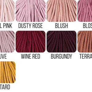 May include: A collection of nine color samples of braided cord arranged in a grid. The colors are labeled as Pastel Pink, Dusty Rose, Blush, Blossom, Mauve, Wine Red, Burgundy, Terracotta, and Mustard, showcasing various shades of pink, red, and yellow.