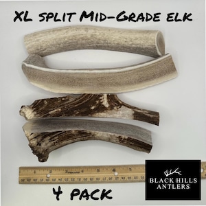 May include: Four split elk antlers, labeled "XL Split Mid-Grade Elk" and "4 Pack". The antlers are light brown and have a natural, rough texture. The antlers are arranged on a white surface with a ruler for scale.
