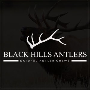 May include: Black Hills Antlers logo featuring a white silhouette of an elk's antlers against a black background. The text "Black Hills Antlers" and "Natural Antler Chews" is in white.