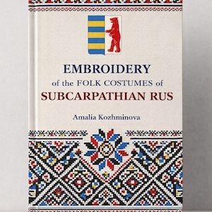 May include: A hardcover book titled "EMBROIDERY of the FOLK COSTUMES of SUBCARPATHIAN RUS" by Amalia Kozhminova. The cover features a colorful embroidered design and a coat of arms with a bear. The year 1922 is printed at the bottom.