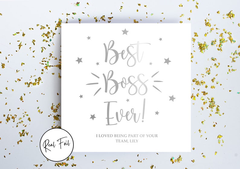 May include: A square white greeting card featuring silver foil text that reads Best Boss Ever! and I LOVED BEING PART OF YOUR TEAM, LILY. The card is decorated with silver foil stars and is surrounded by scattered gold confetti on a white surface.