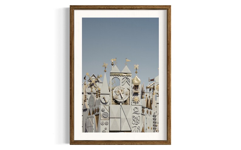 K&ouml;nnte beinhalten: Ein Vintage-Foto eines wei&szlig;en und goldenen Geb&auml;udes mit einem Zifferblatt und komplizierten Details. Das Geb&auml;ude steht vor einem blauen Himmel.