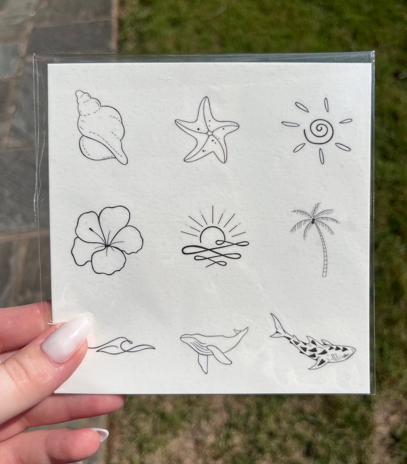 May include: A sheet of temporary tattoos featuring a range of summer-themed designs, including a seashell, starfish, sun, hibiscus flower, palm tree, whale, shark, and waves.