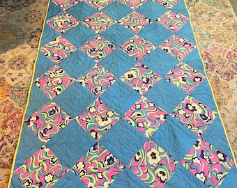 May include: A blue and pink patchwork quilt with a diamond pattern. The quilt is made of different fabrics with a floral design.