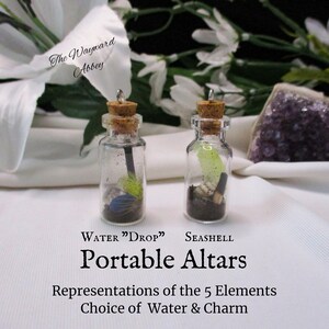 Puede incluir: Dos pequeñas botellas de vidrio con tapones de corcho y amuletos en su interior. Las botellas están etiquetadas con "WATER "DROP" y "SEASHELL". El texto "Portable Altars" está debajo de las botellas. El texto "Representations of the 5 Elements Choice of Water & Charm" está debajo del texto "Portable Altars".