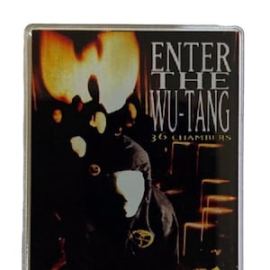Puede incluir: Un logotipo amarillo y negro de Wu-Tang Clan con el texto "Enter the Wu-Tang 36 Chambers" y "Parental Advisory Explicit Content" sobre un fondo negro.