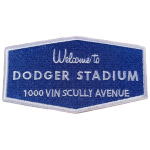 May include: A blue and white embroidered patch with the text "Welcome to Dodger Stadium 1000 Vin Scully Avenue".