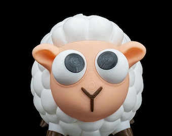 May include: A whimsical, 3D-printed sheep figurine with large, expressive eyes. The sheep features a fluffy white wool coat, tan face and ears, and brown hooves. The background is solid black, highlighting the toy's playful design.