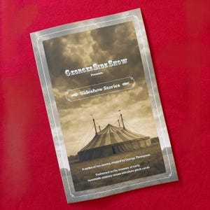 May include: A vintage-style card with the text "GEORGES SIDE SHOW Presents Sideshow Stories." The card features a sepia-toned image of a circus tent under a cloudy sky. Text at the bottom reads "A series of ten stories..." on a red background.