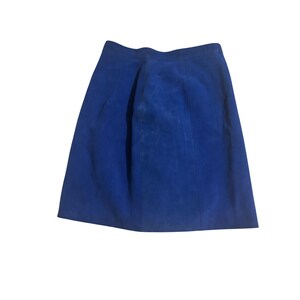 May include: A vibrant blue suede skirt. The skirt has a classic A-line silhouette, with a fitted waist and a gently flared hem. The rich blue color is consistent throughout the skirt, and the suede texture adds a touch of luxury. The skirt is a versatile piece.