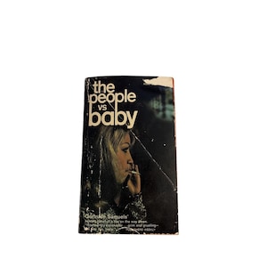 Pode incluir: Um livro de bolso intitulado The People vs Baby com uma capa escura apresentando o perfil de uma pessoa com cabelo loiro fumando um cigarro. O título está impresso em uma fonte branca grande sem serifa no topo, com texto na parte inferior.