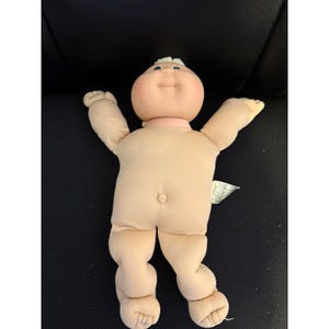 May include: A set of three ceramic mugs with a speckled, matte finish. The mugs are in shades of cream, light gray, and dark gray. Each mug has a simple, minimalist design and a rounded handle.