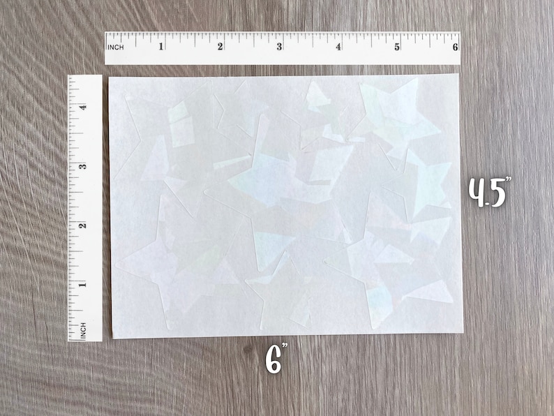 May include: A sheet of white iridescent vinyl with multiple star shapes cut out. The sheet measures 6 inches by 4.5 inches.