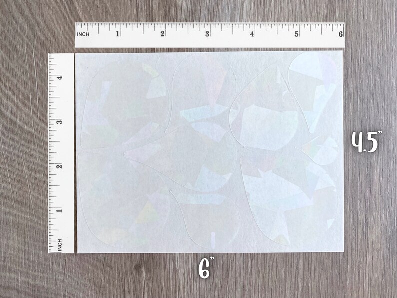 May include: A sheet of iridescent vinyl with a variety of geometric shapes cut out. The sheet measures 6 inches by 4.5 inches.