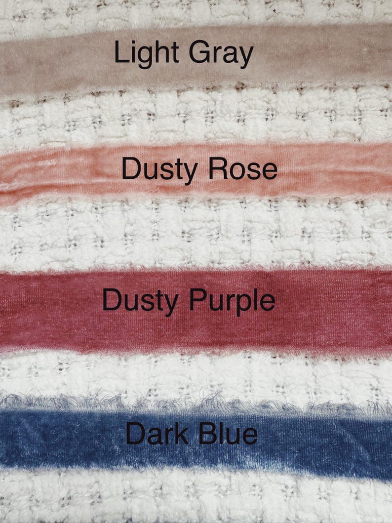 May include: Four fabric swatches in different colors: light gray, dusty rose, dusty purple, and dark blue. The swatches are arranged vertically on a white textured surface.