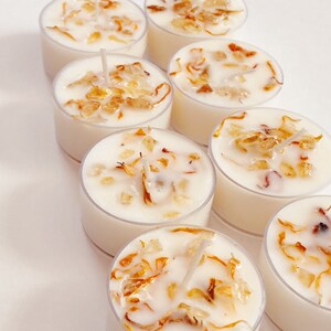 Peut inclure: Un ensemble de sept bougies chauffe-plat blanches avec des p&eacute;tales de fleurs s&eacute;ch&eacute;es incrust&eacute;s dans la cire. Les bougies sont dispos&eacute;es en rang&eacute;e, la m&egrave;che vers le haut.