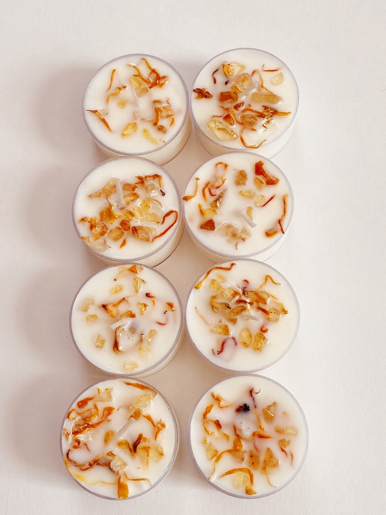 Peut inclure: Huit bougies chauffe-plat blanches dans des contenants transparents. Chaque bougie contient de petits morceaux de cristaux orange et bruns incrust&eacute;s dans la cire.