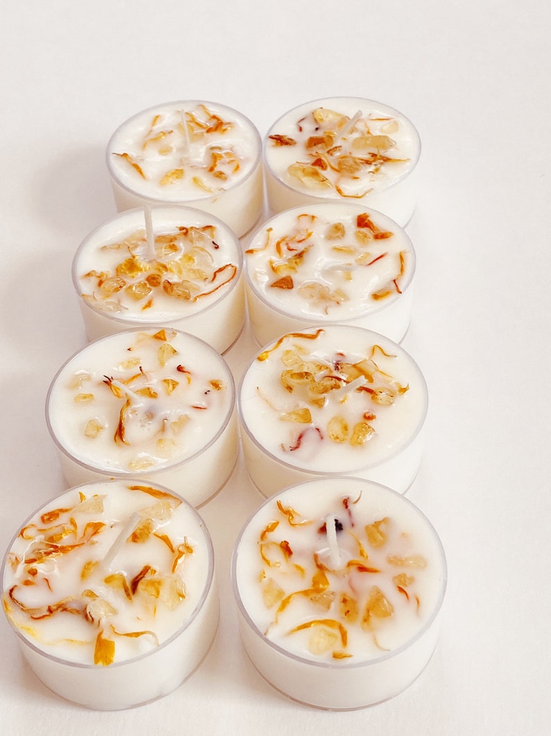 Peut inclure: Huit bougies chauffe-plat blanches avec une cire transparente et des p&eacute;tales de fleurs s&eacute;ch&eacute;es &agrave; l'int&eacute;rieur. Les bougies sont dispos&eacute;es en deux rang&eacute;es de quatre.