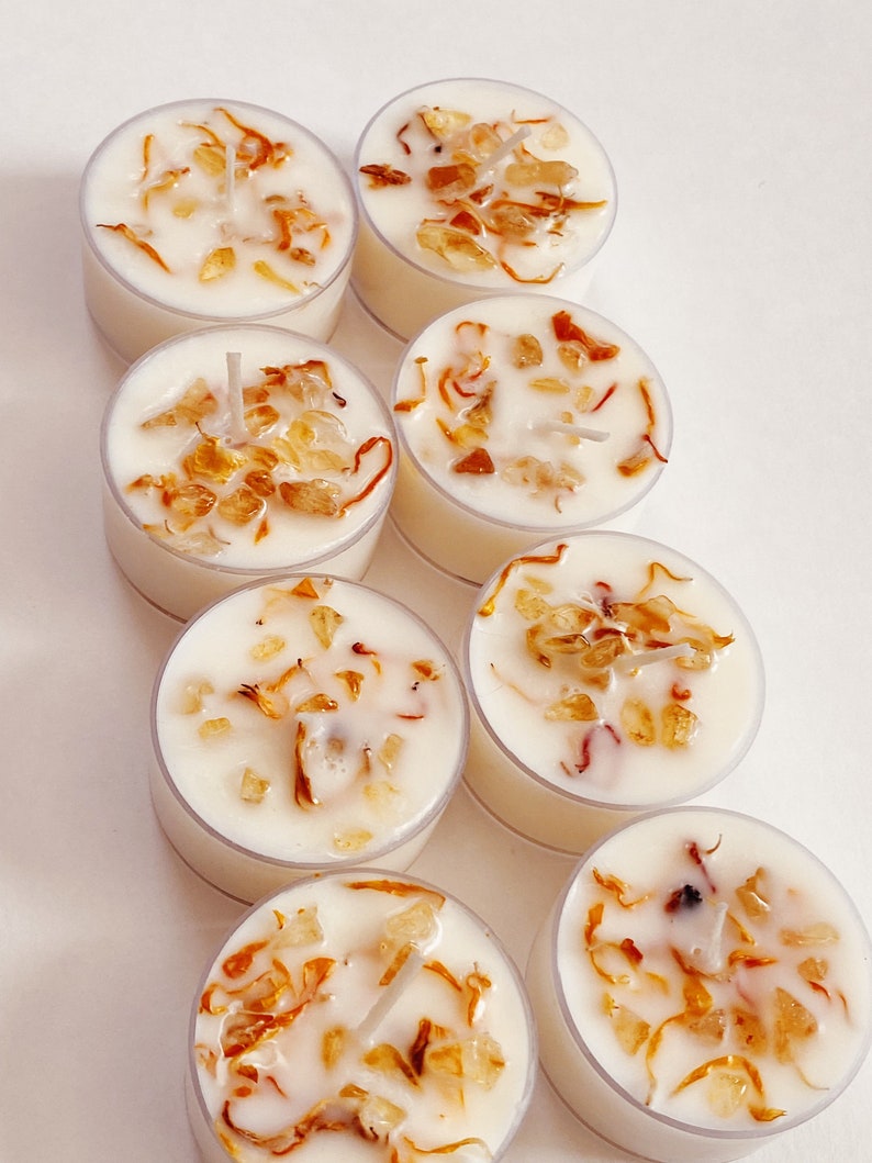 Peut inclure: Huit bougies chauffe-plat blanches avec une cire transparente et de petits morceaux d'&eacute;corce d'orange s&eacute;ch&eacute;e incrust&eacute;s dans la cire.