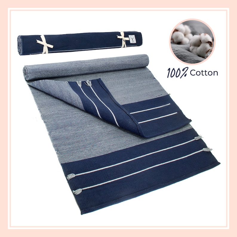 May include: A rolled up navy blue and white striped cotton rug with fringe tassels. The rug is 100% cotton.