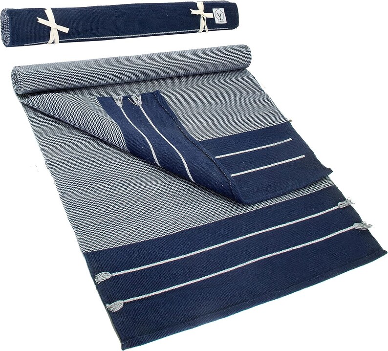 May include: A navy blue and white striped cotton rug with fringe tassels. The rug is rolled up and tied with a white ribbon.
