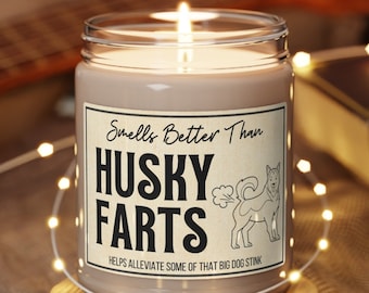 May include: A brown candle in a glass jar with a white label that reads "Smells Better Than Husky Farts" and "Helps Alleviate Some Of That Big Dog Stink."