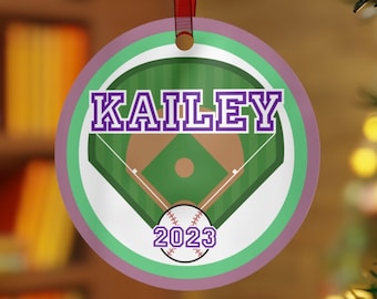 Könnte beinhalten: Ein runder, lila und grüner Weihnachtsbaumschmuck mit einem Baseballfeld-Design. Der Schmuck hat den Namen "KAILEY" und das Jahr "2023" aufgedruckt.