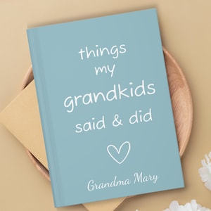 May include: A light blue journal with the text "things my grandkids said & did" in white. A white heart is below the text and the words "Grandma Mary" are at the bottom.