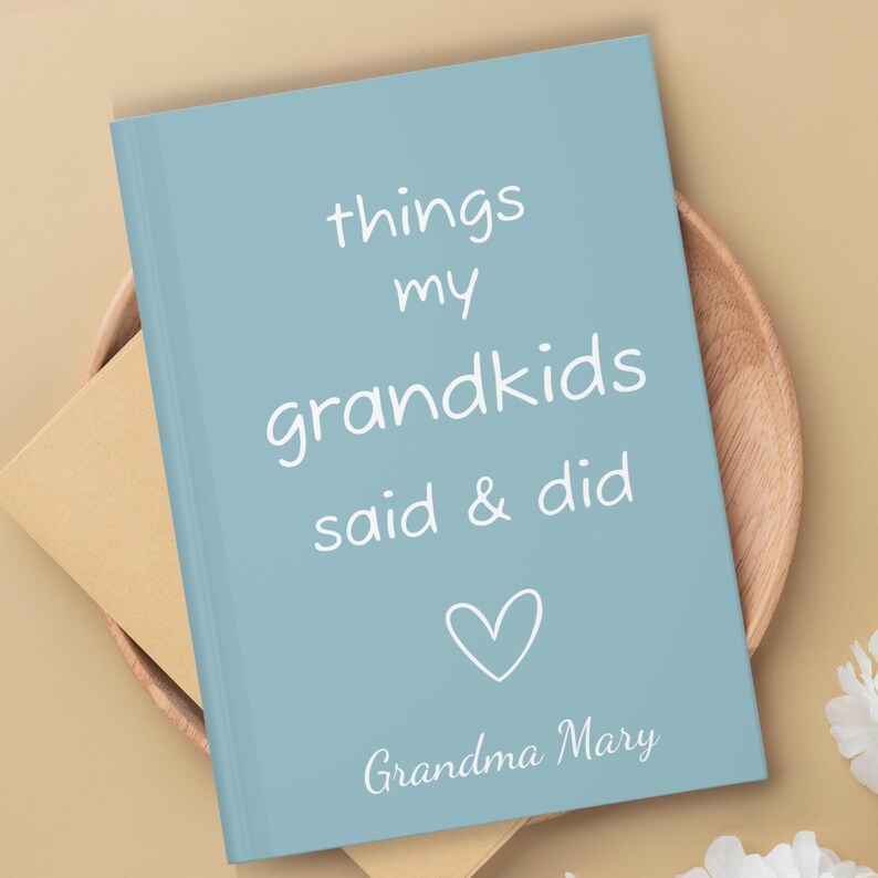 May include: A light blue journal with the text "things my grandkids said & did" in white. A white heart is below the text and the words "Grandma Mary" are at the bottom.