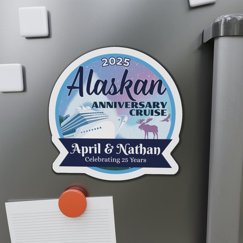 K&ouml;nnte beinhalten: Ein runder blauer und violetter Magnet mit einem wei&szlig;en Kreuzfahrtschiff, einem Elch und dem Text "2025 Alaskan Anniversary Cruise April & Nathan Celebrating 25 Years".