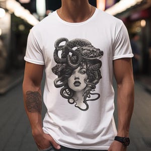 May include: White t-shirt with a black and white graphic print of Medusa, a mythical Greek figure with snakes for hair.