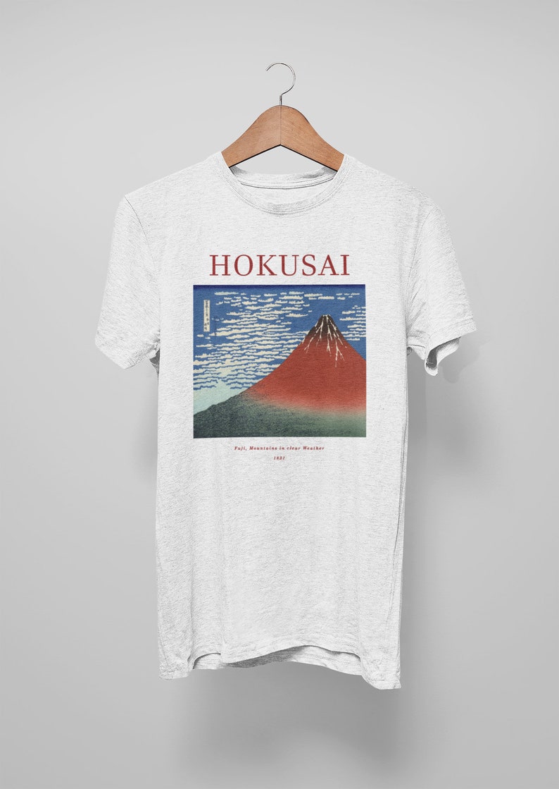 May include: A white t-shirt with a print of a famous Japanese woodblock print by Hokusai, "Fuji Mountain in Clear Weather". The print is in blue, red, and white.