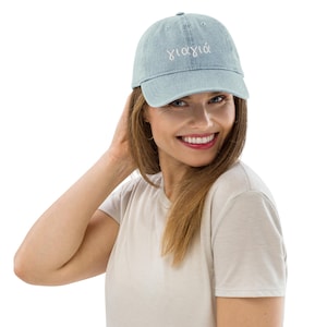 May include: A light blue denim baseball cap with white embroidered text that says "γιαγιά".