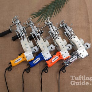 May include: Four electric tufting machines with metal mechanisms and plastic handles in yellow, blue, orange, and clear. Each tool features a black power cord, a side handle, and a label reading Tufting Guide on the grip. The devices are arranged in a row.