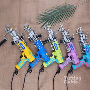 May include: Five electric tufting guns with metal mechanisms and plastic handles in yellow, blue, lime green, lavender, and turquoise. Each tool features a blue label with the text TuftingGuide and a black power cord extending from the base.