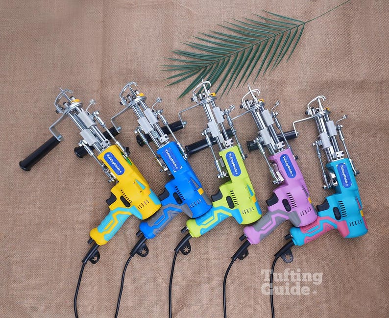May include: Five electric tufting guns with metal mechanisms and plastic handles in yellow, blue, lime green, lavender, and turquoise. Each tool features a blue label with the text TuftingGuide and a black power cord extending from the base.