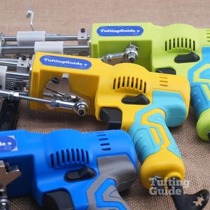 May include: Three electric tufting machines with metal needles and mechanisms. The machines feature plastic casings in lime green, yellow, and blue with light blue or grey accents. Each device displays a blue label with the text TuftingGuide.