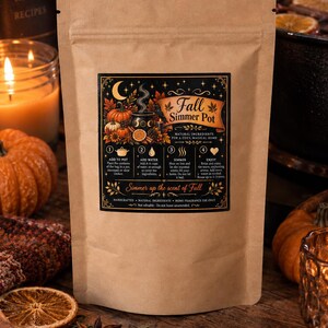 May include: A brown paper pouch featuring a black rectangular label with gold text and illustrations. The label reads Fall Simmer Pot, includes instructions for use, and depicts a cauldron, pumpkins, and stars. The pouch is for home fragrance.