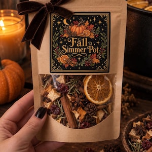 May include: A brown paper pouch containing a fall simmer pot mix, featuring a dark label with the text Fall Simmer Pot, a pumpkin, and autumn leaves. The clear window reveals dried orange slices, cinnamon sticks, star anise, and cranberries.