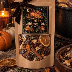 May include: A brown paper pouch containing a Fall Simmer Pot blend, featuring a dark label with the text Fall Simmer Pot, a pumpkin, and foliage. The pouch is tied with a dark brown velvet ribbon and has a clear window revealing dried orange slices, cinnamon sticks, star anise, pinecones, and cranberries.