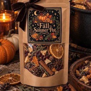 May include: A brown paper pouch containing a Fall Simmer Pot blend, featuring a dark label with the text Fall Simmer Pot, a pumpkin, and foliage. The pouch is tied with a dark brown velvet ribbon and has a clear window revealing dried orange slices, cinnamon sticks, star anise, pinecones, and cranberries.