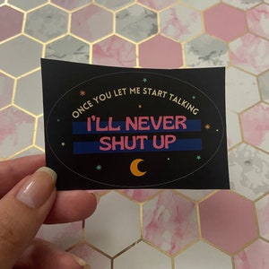 May include: Black sticker with a white oval border and the text "Once you let me start talking I'll never shut up" in pink and blue. The sticker has a crescent moon and stars.