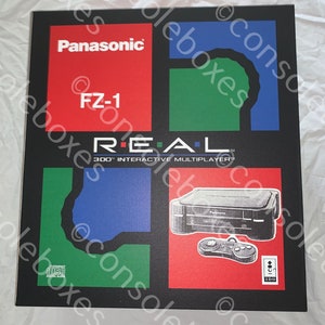 May include: A black box with a red, green, and blue design. The box has the text "Panasonic", "FZ-1", "REAL", "300™ INTERACTIVE MULTIPLAYER™", and "ICB 3D0". The box also has a picture of a black console and a black controller.