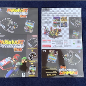 Puede incluir: Dos cajas de juego Mario Kart Double Dash!! Pak. La parte frontal de la caja presenta a Mario y Luigi en sus karts. Las cajas incluyen una consola Nintendo GameCube, un mando y el juego Mario Kart Double Dash!!