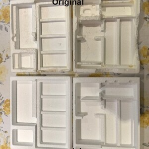 May include: Four white styrofoam boxes with different compartments for storing video game consoles and accessories. The boxes are labeled "consoleboxes".