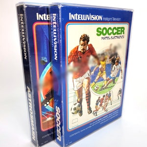 May include: Two Intellivision game cartridges, one for AstroSmash and one for Soccer. Both cartridges are in clear plastic protectors. The Soccer cartridge has a blue and white box with a picture of a soccer player on the front. The AstroSmash cartridge has a blue and orange box with a picture of a spaceship on the front.